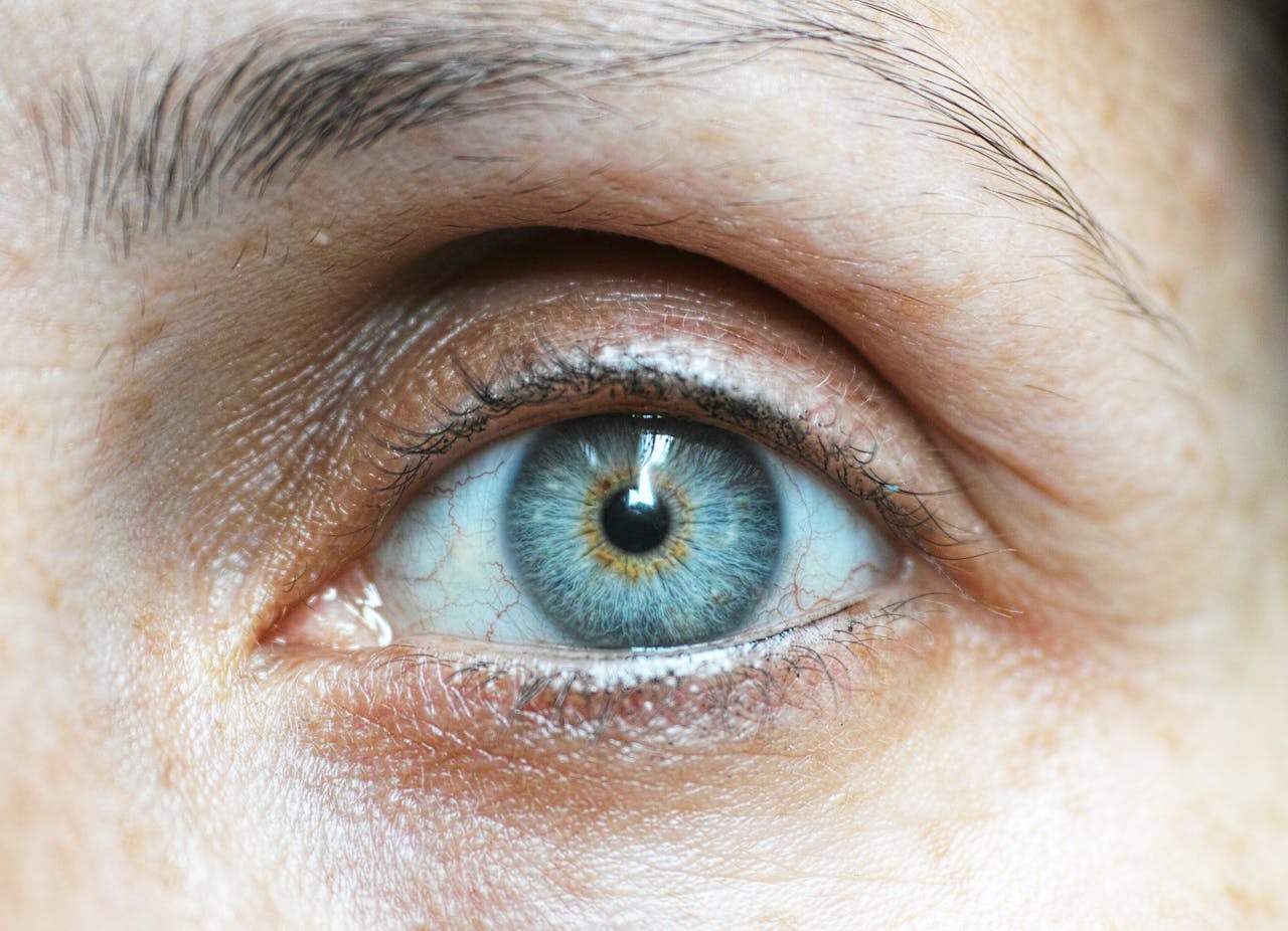 Detailed close-up image of a woman's blue eye revealing intricate details.