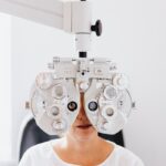 Close-up of a woman undergoing an eye examination using a phoropter in a clinic.