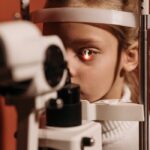 Young girl having an eye exam with ophthalmic equipment in a clinic.