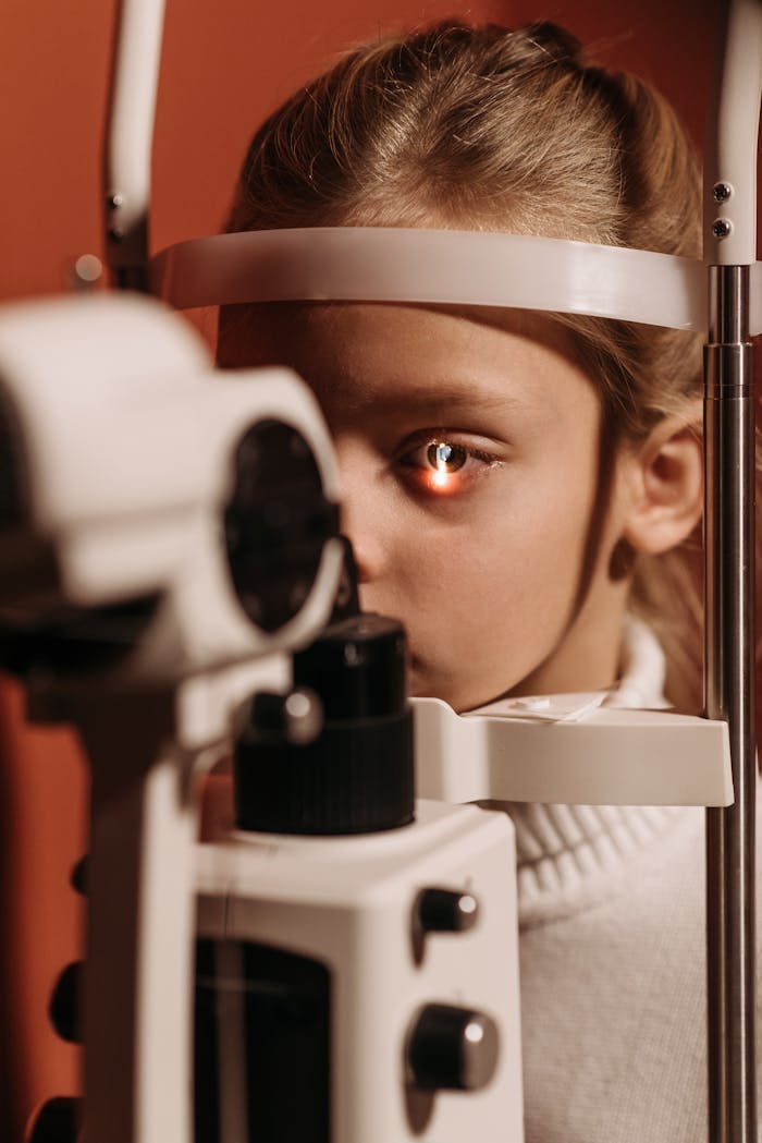 Young girl having an eye exam with ophthalmic equipment in a clinic.